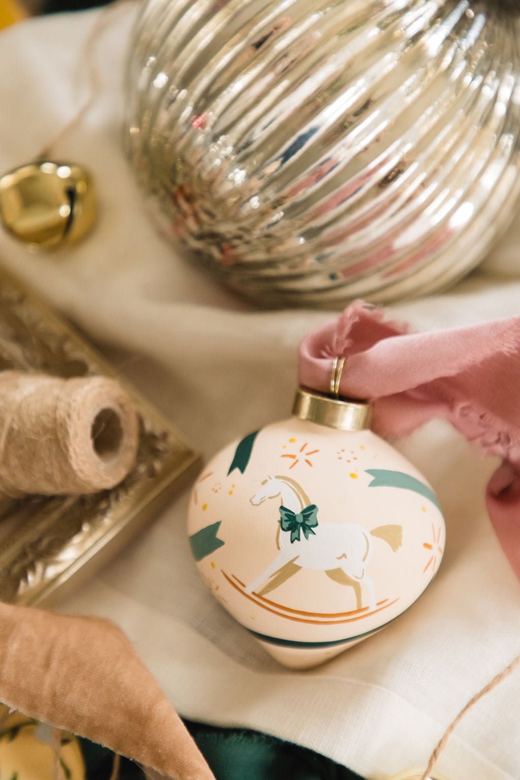 Decorative hand painted porcelain ornament with a rocking horse design, with a blurred background