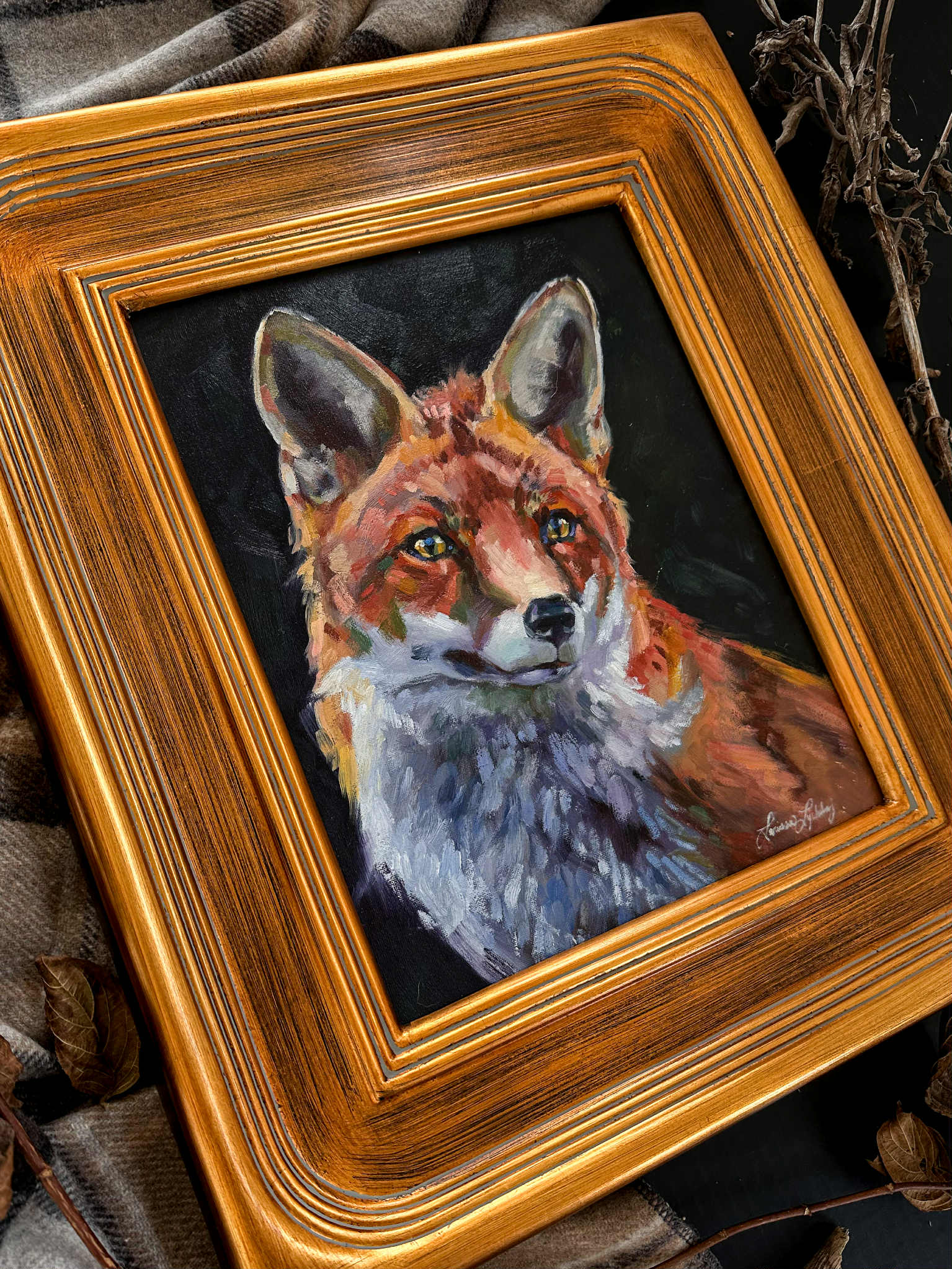 Framed painting of a fox with a gold frame on a dark background