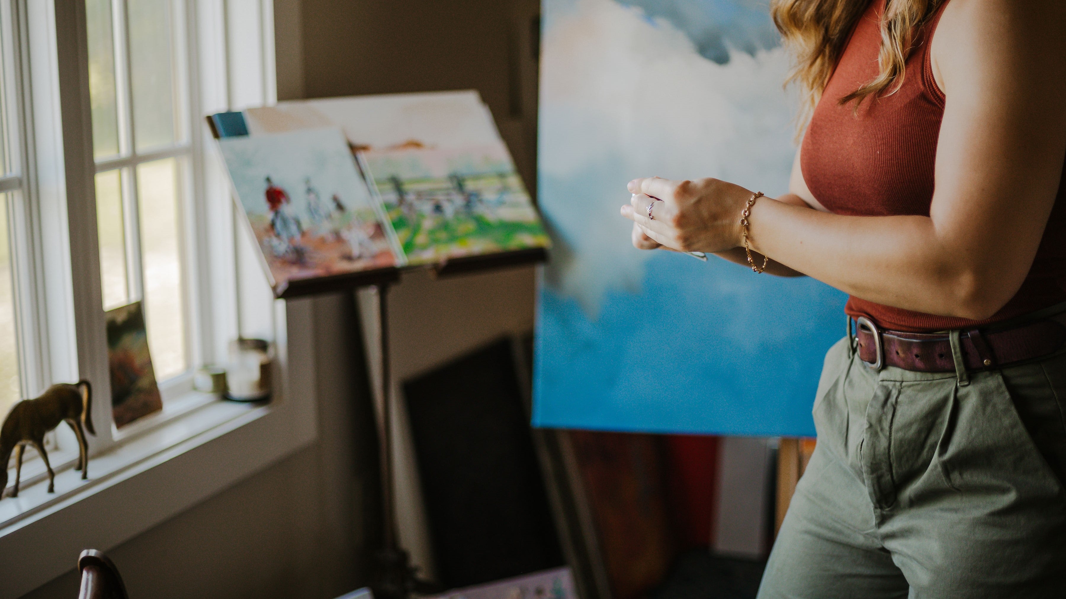Equestrian artist Larissa Ann painting in her art studio