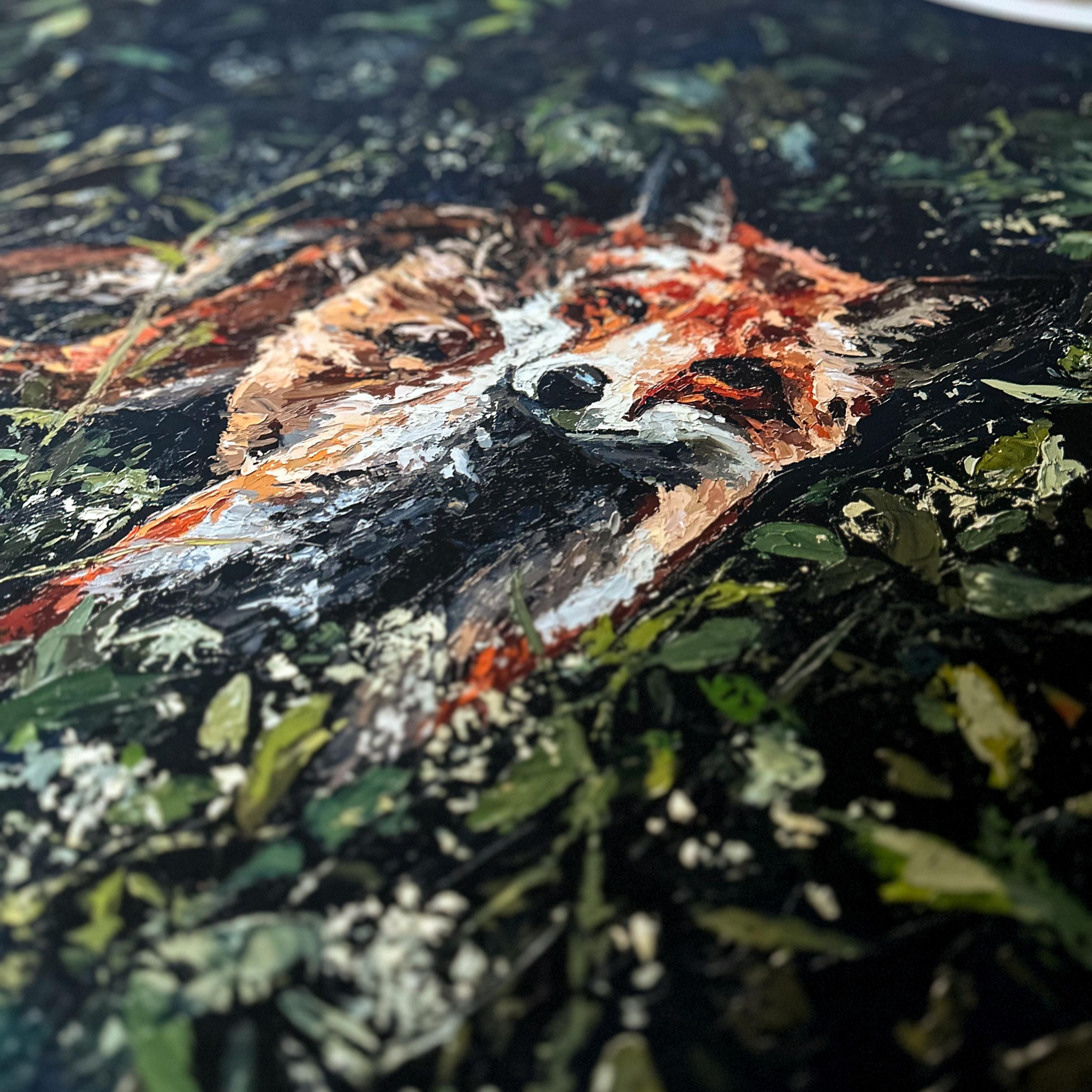 Close-up of a fine art print with a fox's face surrounded by green foliage.