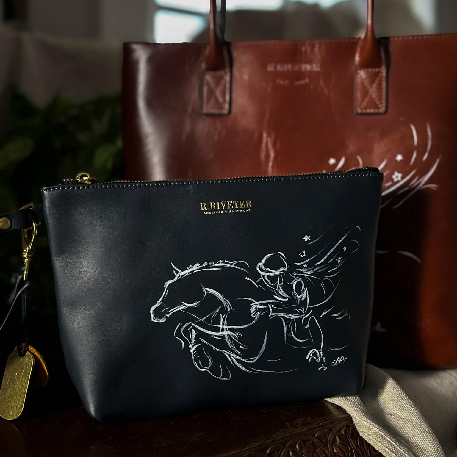 Bespoke hand painted leather bags with equestrian designs by artist Larissa Ann