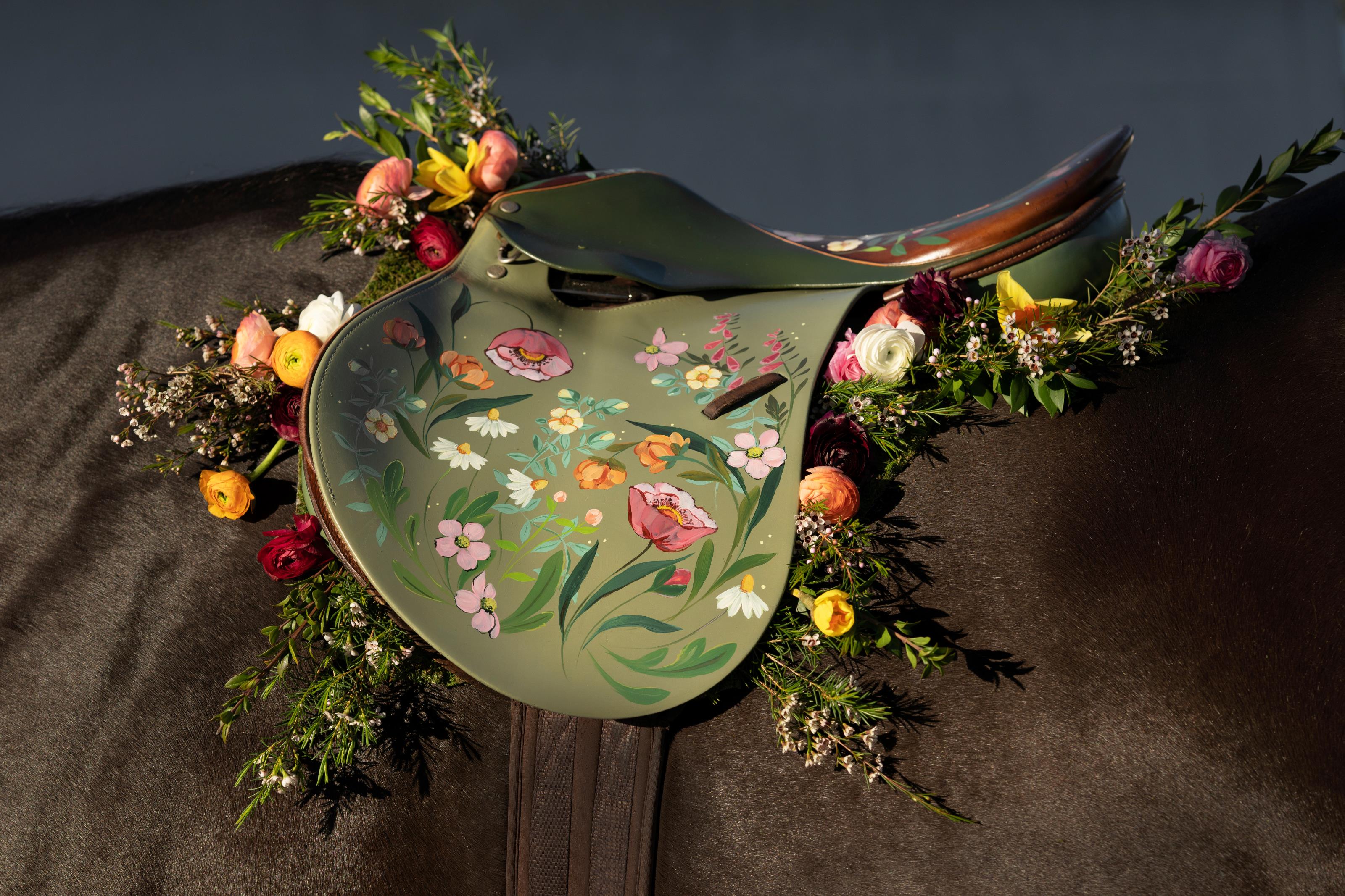 Decorative hand painted horse saddle by equestrian artist Larissa Ann with floral patterns and details