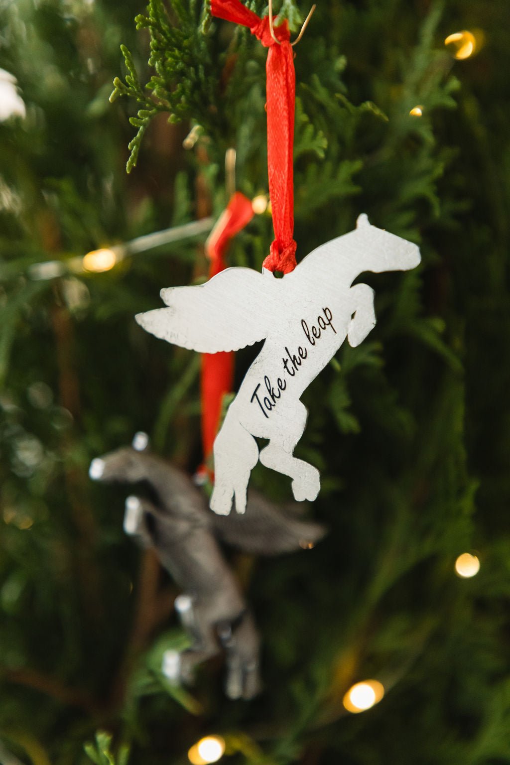 Pegasus ornament with 'Take the leap' text on a Christmas tree.